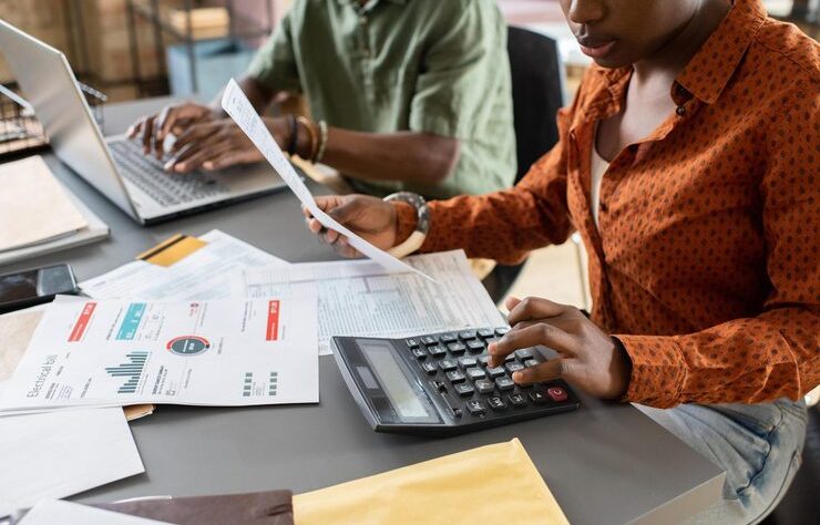young-african-businesswoman-accountant-pushing-buttons-calculator